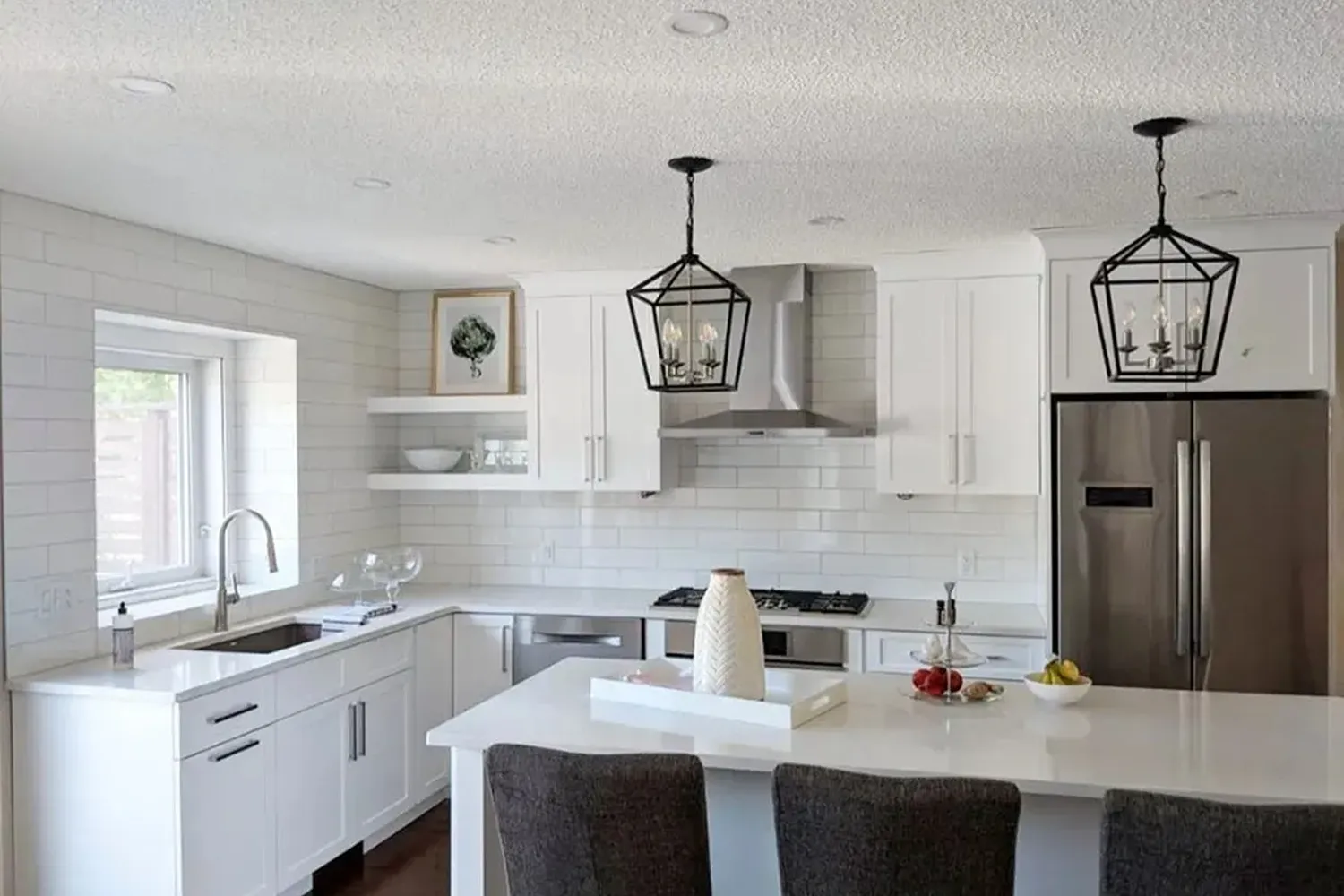 Kitchen renovation featuring white shaker cabinets, the removal of a support wall to open the space and installation of a kitchen island in Edmonton