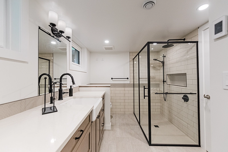 Basement bathroom with a double vanity, black fixtures, and a glass walk-in shower, renovated as part of a full house project in Edmonton