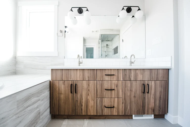 Dual vanity with walnut cabinetry, white quartz countertop, and black hardware in primary ensuite — Edmonton second-story home addition