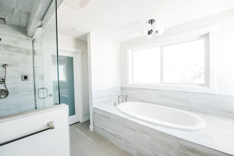 Primary ensuite layout showing glass steam shower and soaker tub side by side — second-story addition in Edmonton