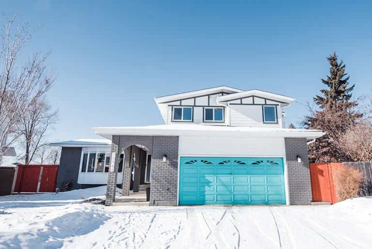 Exterior view of second-story addition above garage in Ermineskin, Edmonton — new upper level with large windows integrated into existing brick home