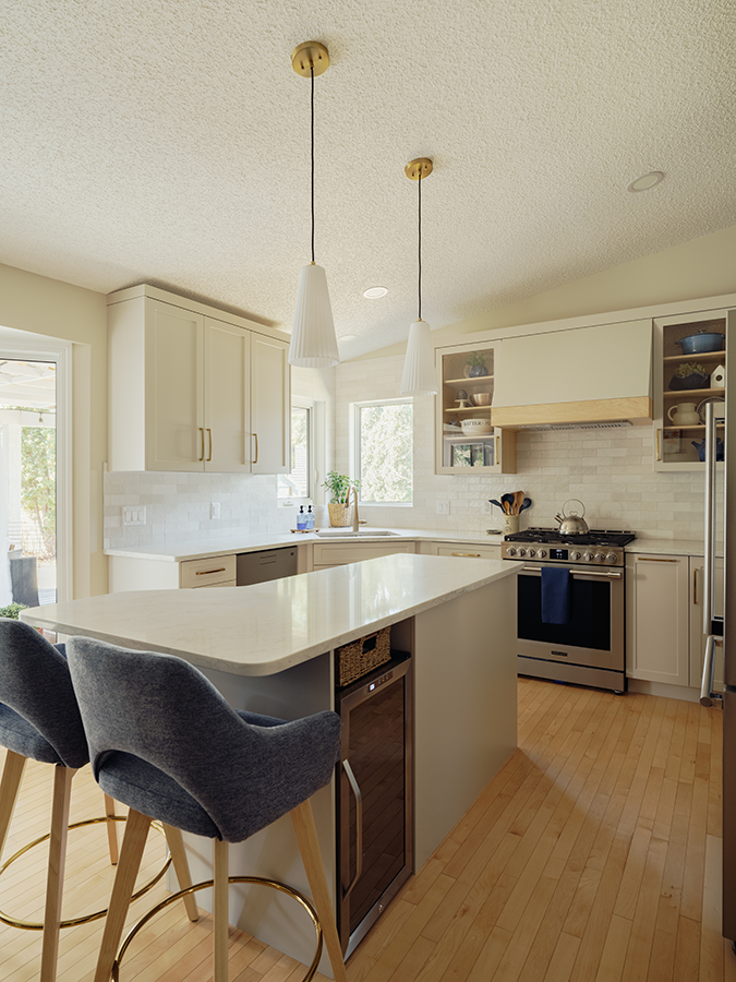 Custom kitchen island with quartz countertop and bar stools, pendant lights overhead — kitchen renovation in Spruce Grove, AB