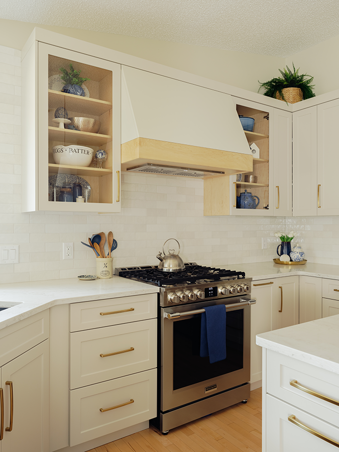 Gas range with natural maple hood valance, open shelving, and white tile backsplash — kitchen renovation in Spruce Grove, AB